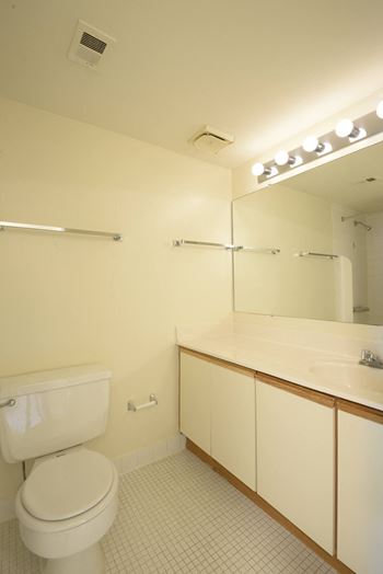 a bathroom with a toilet sink and mirror  at Charlesgate Apartments, Towson, Maryland